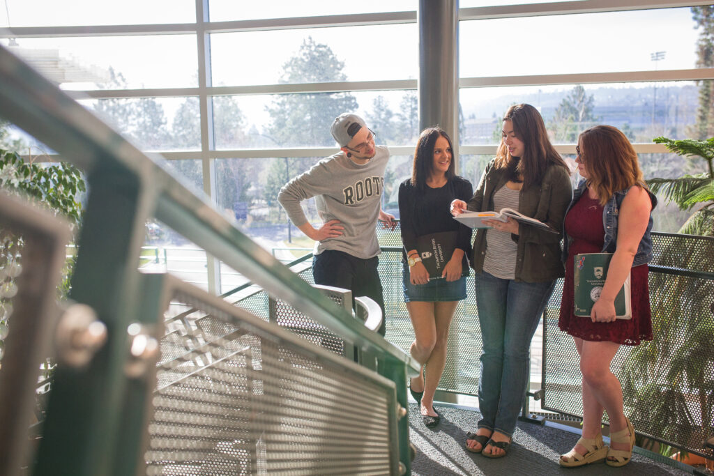 Students talking on the stairs of the Trades and Technology building.