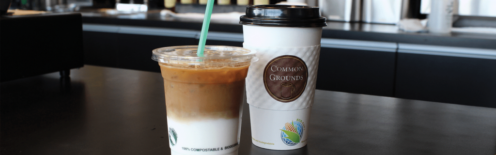 An iced latte and a paper coffee cup with the Common Grounds logo on the sleeve.
