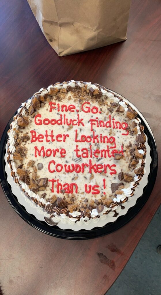 Cake with the words "Fine. Go. Good luck finding better looking more talented coworkers than us!" in icing.